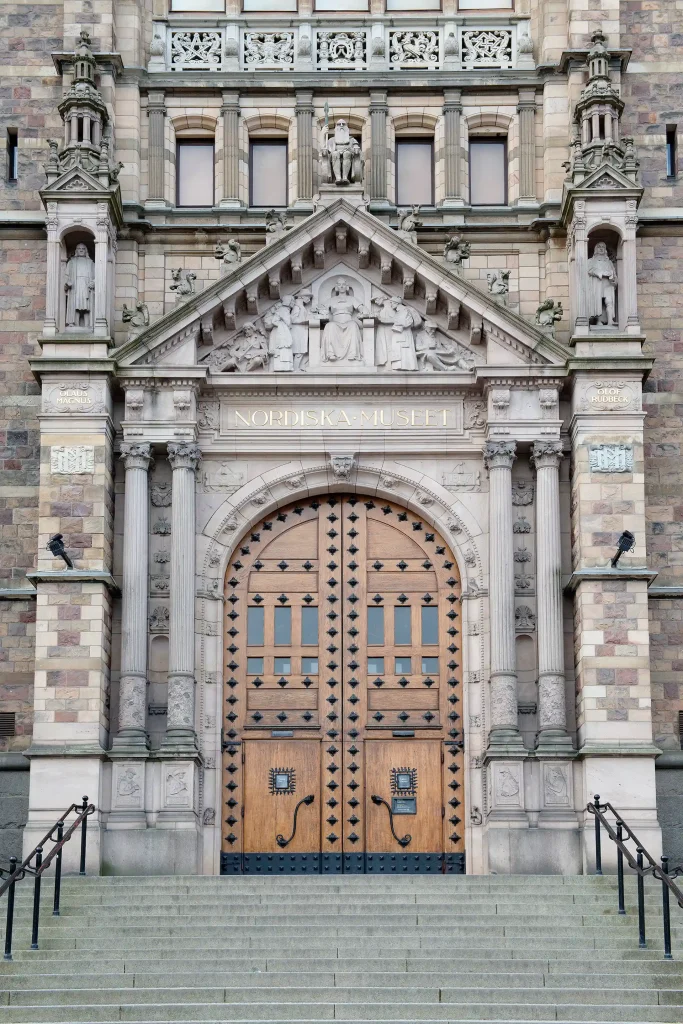 Grand and impressive entrance with a wooden door, staircase, and a stone façade.