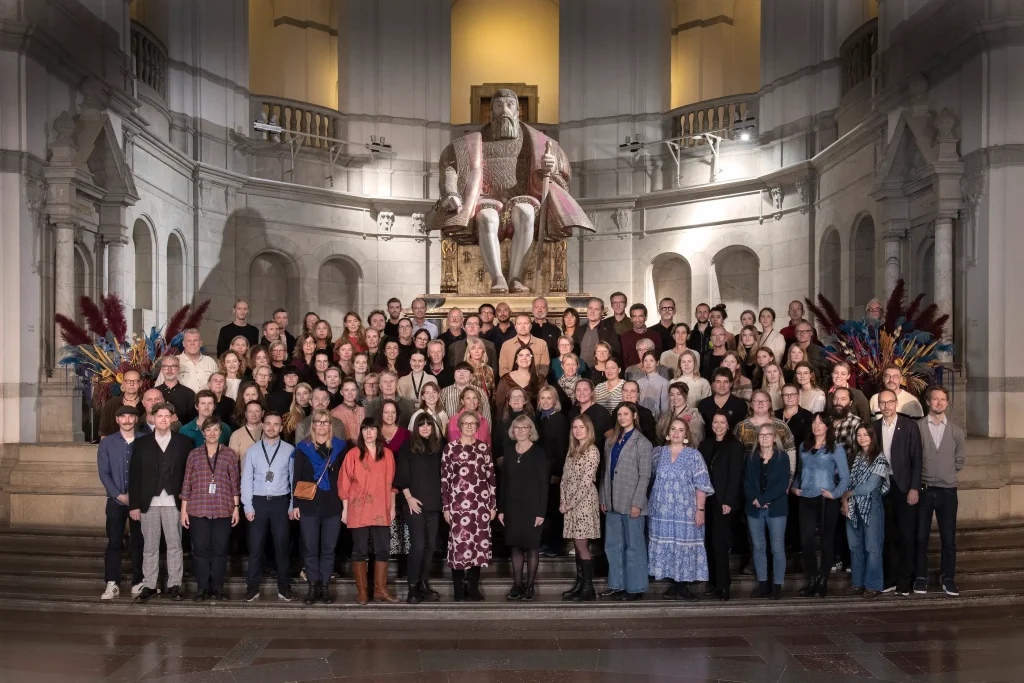 Cirka 100 personer står på en trappa med en skulptur av Gustav Vasa i bakgrunden