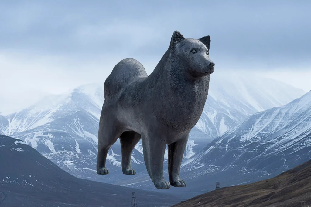 En staty av en lapphund mot bakgrund av ett snöigt berg.