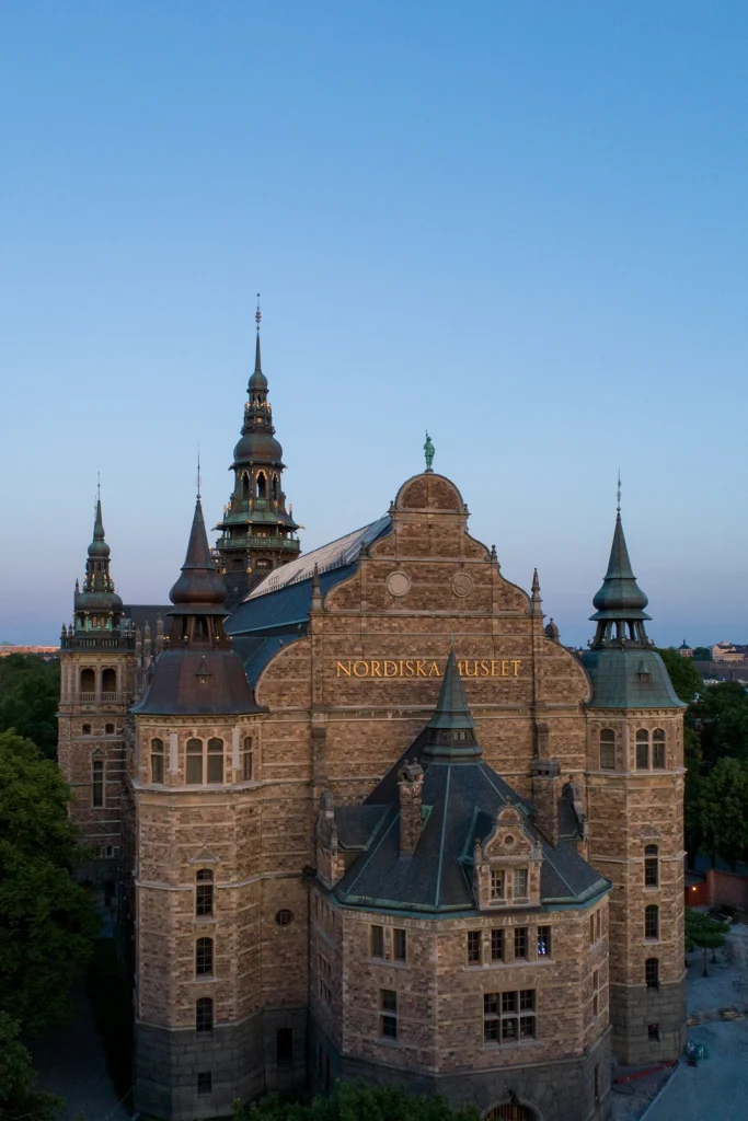Nordiska museet sett från Strandvägen i Stockholm mot blå himmel.