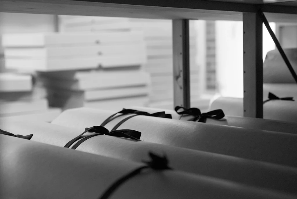 Svartvit bild på arkivrullar i en hylla