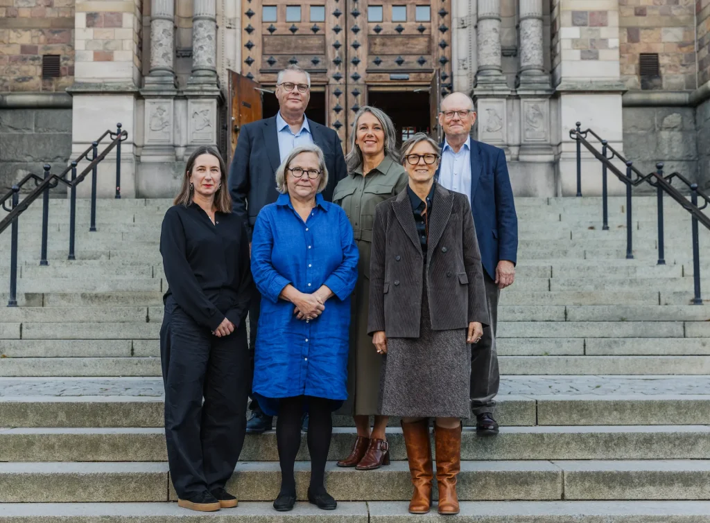 En grupp om sex personer står på trappan vid Nordiska museet.
