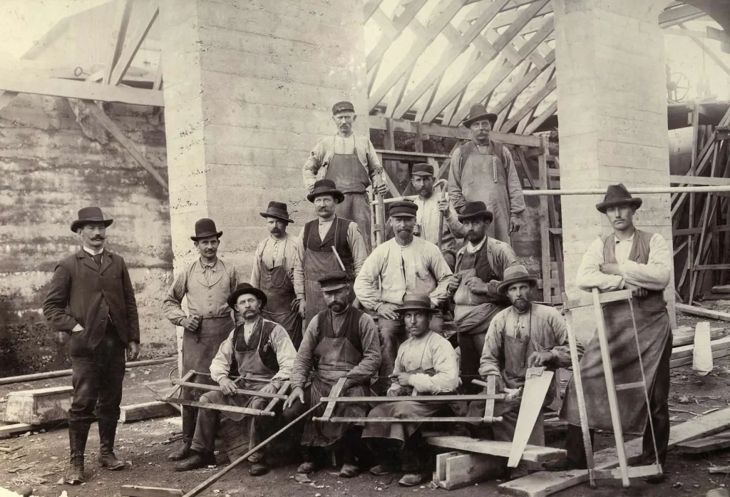 En grupp byggnadsarbetare med mustascher och hattar vid bygget av Nordiska museet