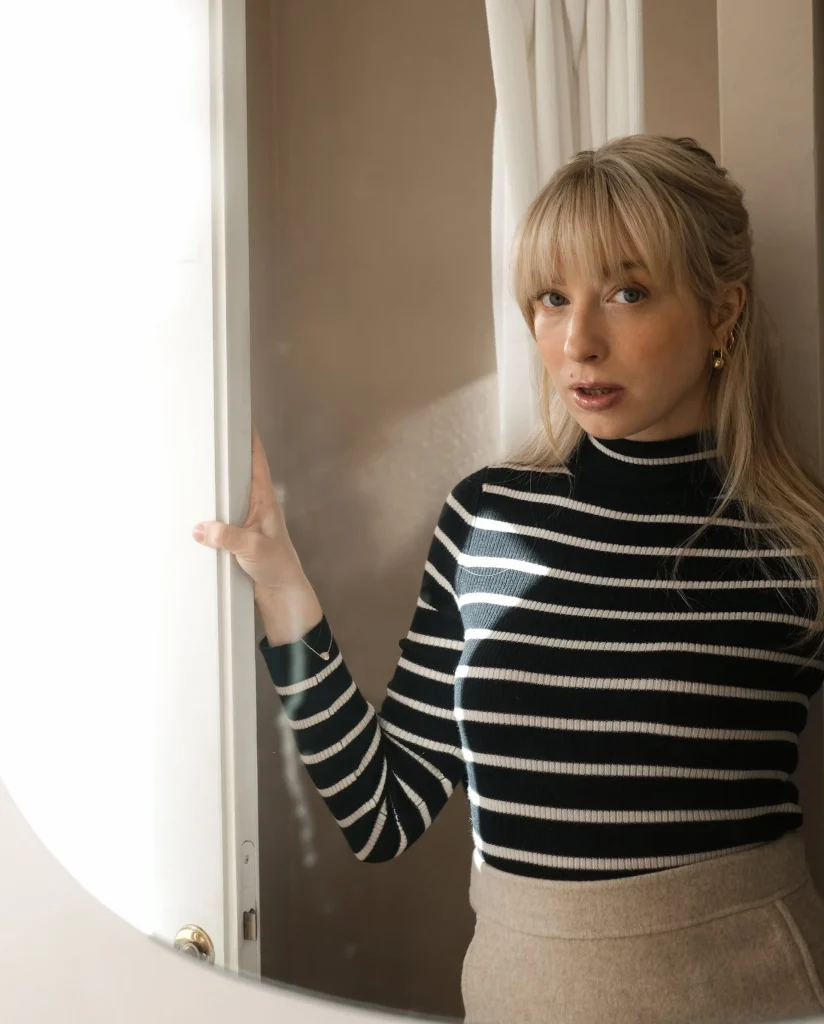 En kvinna med långt ljust hår och randig polotröja