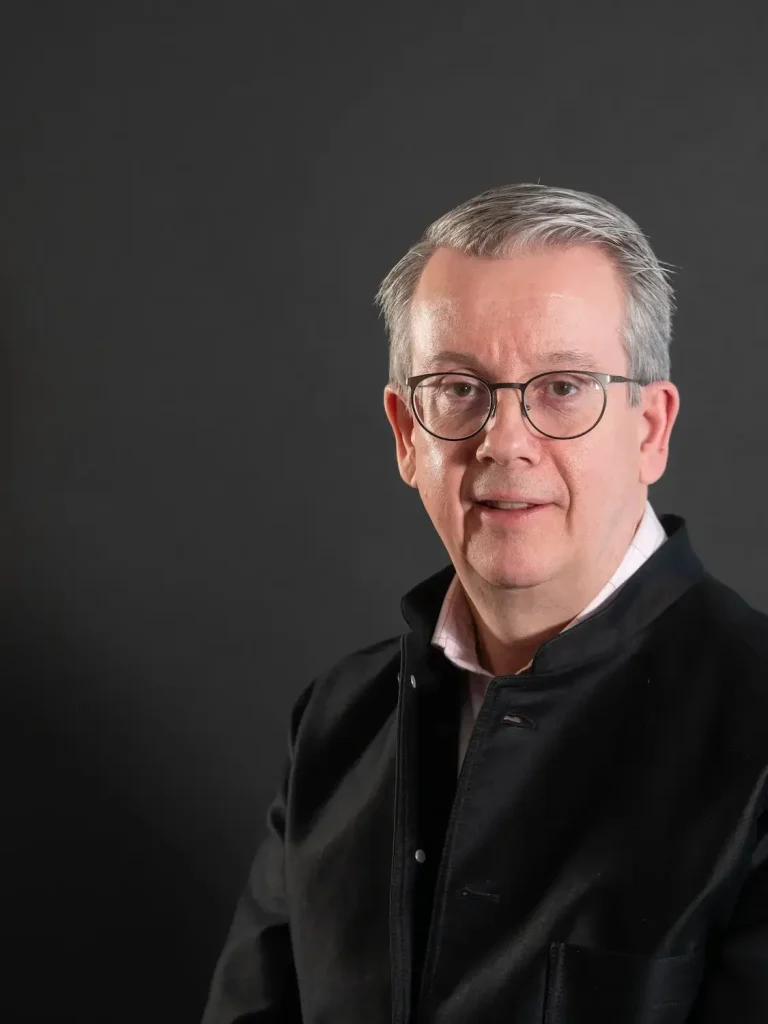 Foto på en man med svart tröja och glasögon.