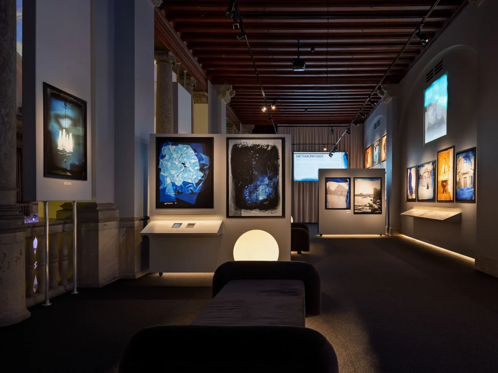 Ett galleri med stora fotografier både printade och digitala projiceringar, divaner och kolonner