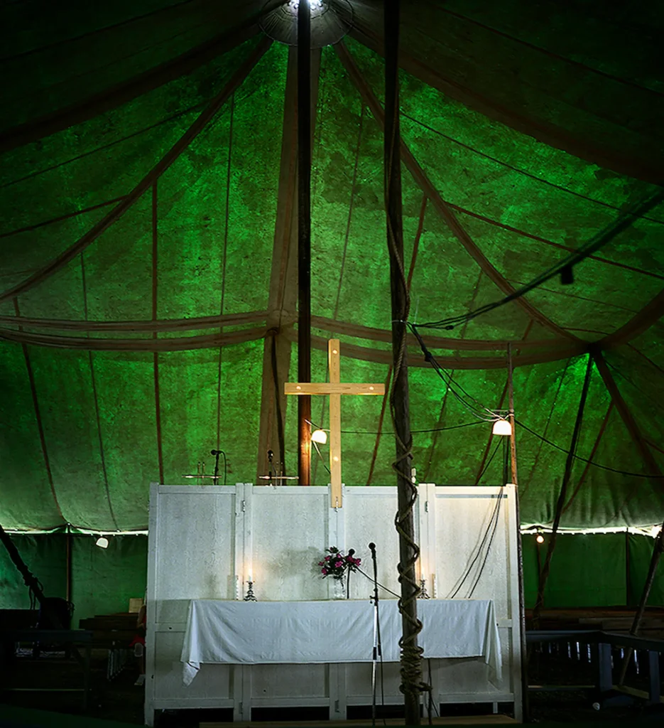 Ett altare och stort träskors under en görn tältduk